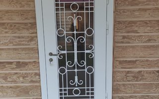 стальная дверь с ажурной кованой решеткой для загородного деревянного дома
